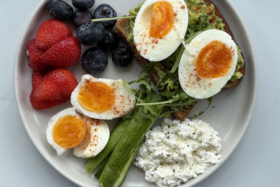 Eggs and avocado on toast with berries and cottage cheese